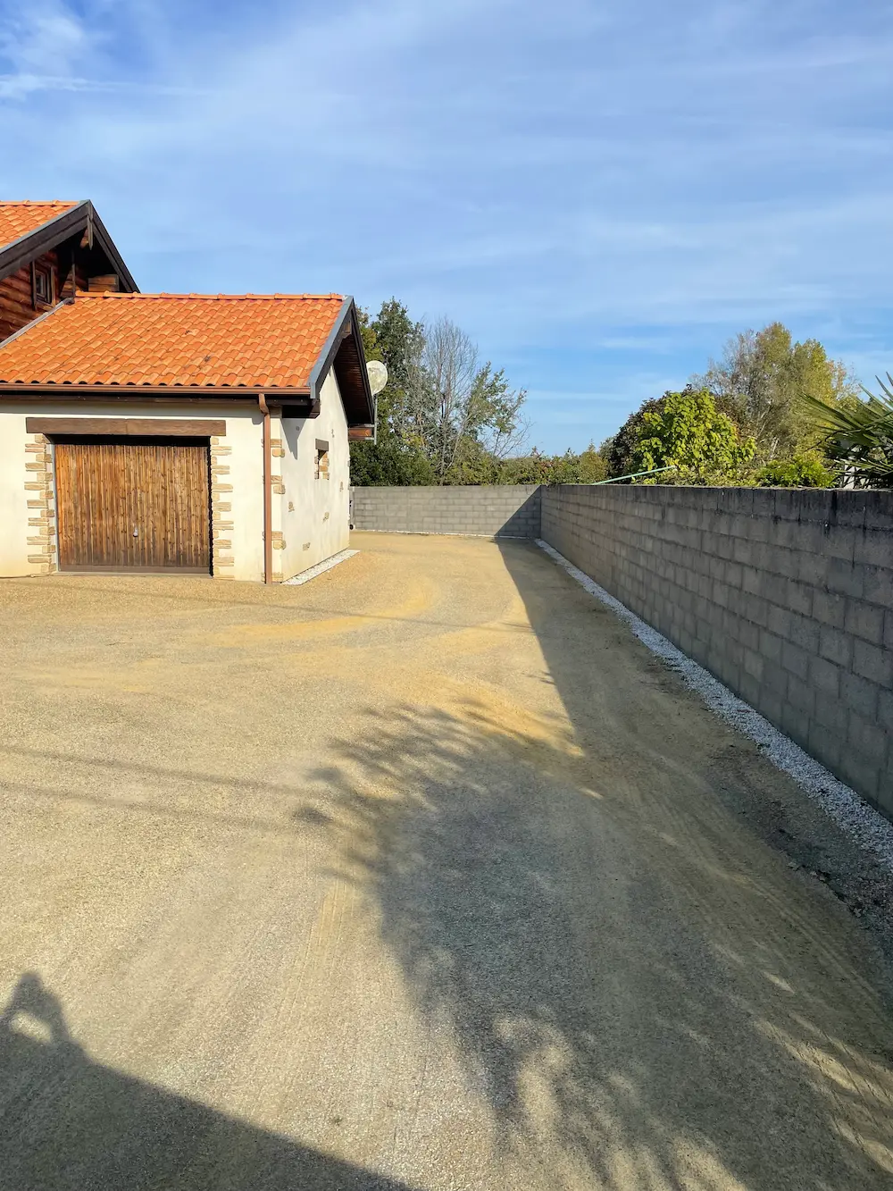 Chantier de terrassement et préparation de sol avant la pose d'un enrobé dans une cour de maison à La Plaine-sur-Mer (44).
