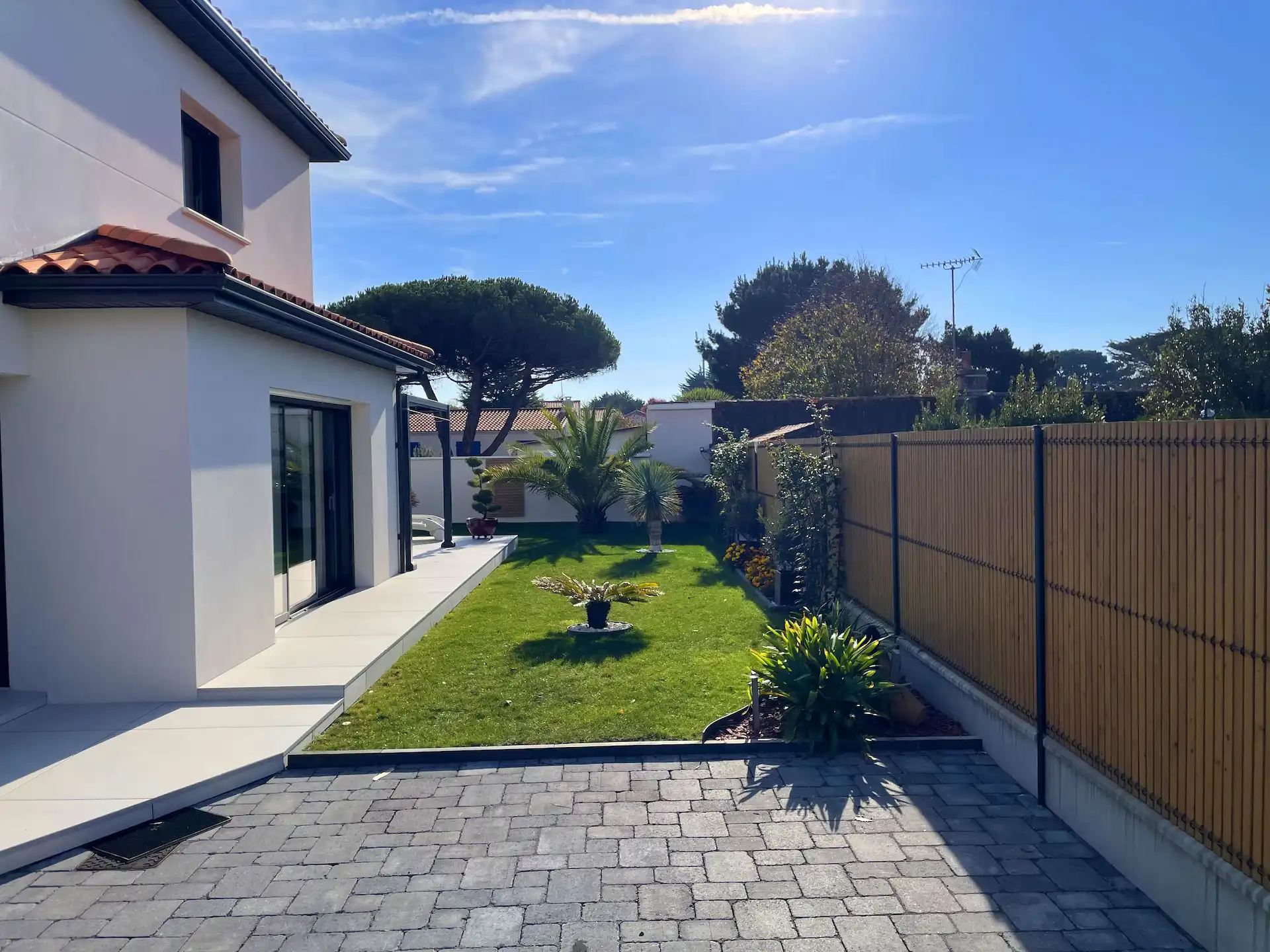 Création paysagère d'un jardin avec une cour en pavés gris réalisée par Thomas Paysage à Pornic.