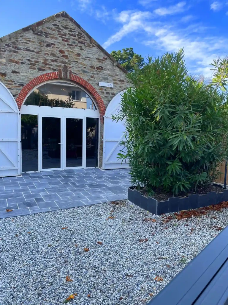 Aménagement global d'un extérieur avec création d'une terrasse et d'une cour en gravier par Thomas Paysage à Préfailles.